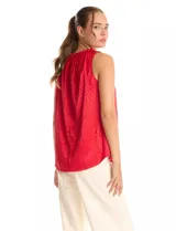 Blusa sin mangas color rojo, confeccionada en satén labrado con un patrón sutil de corazones. Presenta cuello alto con detalle de punto smock fruncido.