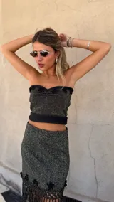 Falda asimétrica de tejido lurex negro y dorado, con pretina elástica y apliques de crochet en el ruedo.