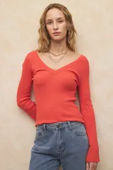 Top tejido de manga larga color coral/rojo, con escote en V pronunciado tanto en el frente como en la espalda, y puños acampanados.