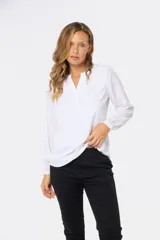 Blusa de manga larga con escote en V, confeccionada en tela suave y sedosa con doble capa frontal para mayor opacidad.