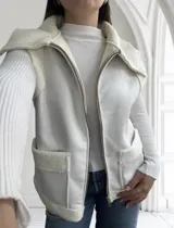 Chaleco blanco con cierre frontal, cuello y bolsillos con textura de piel sintética.
