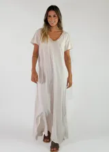 Vestido largo color gris claro, de corte amplio y relajado, con mangas cortas y detalle de volados en el escote en V.