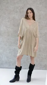 Vestido corto color beige, de raso, con escote en V y mangas 3/4. Corte holgado.