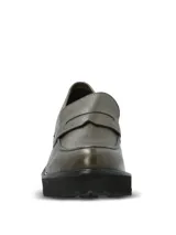 Mocasines de cuero color verde oliva con textura granulada, diseño tipo penny loafer y suela track de plataforma alta en color negro.