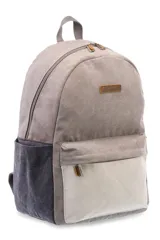 Mochila azul de lona tipo canvas con bolsillo frontal y logo de la marca en etiqueta de cuero.