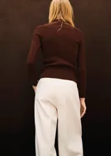 Cardigan de punto fino color marrón chocolate, con diseño entallado, cuello redondo y cierre frontal completo con botones pequeños. Presenta textura acanalada y mangas largas.