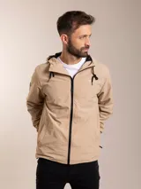 Campera de nylon con capucha, cierre frontal y forro de red. Presenta un diseño minimalista en color beige con detalles en negro.