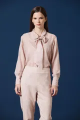 Pantalon de vestir de corte recto y silueta amplia, confeccionado en tela fluida con sutil estampado jacquard tono sobre tono. Presenta cintura alta con pretina ancha y cierre frontal oculto.