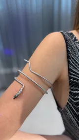 Brazalete de brazo con diseño de serpiente en color plateado, con textura escamada y acabado brillante.