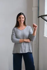 Remera de algodón gris con cuello en V, mangas largas y corte holgado con ruedo asimétrico.