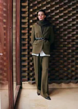 Pantalón de vestir verde militar, de corte recto y tiro alto, con bolsillos laterales y raya central marcada.