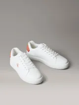 Zapatillas urbanas Calvin Klein de diseño clásico cupsole, color blanco con detalles en salmón, confeccionadas en piel lisa, con suela de TPU flexible y cordones tradicionales.