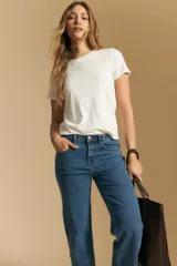 Jean de corte recto y tiro medio, confeccionado en denim elastizado de color negro. Presenta un diseño clásico con cierre de botón y cremallera, bolsillos laterales y traseros, y ruedo con terminación deshilachada.