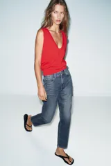 Jeans de tiro alto con corte mom fit, cinco bolsillos y cierre frontal con cremallera y botón.