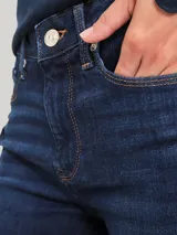 Pantalón de jeans Tommy Hilfiger de corte skinny, color azul oscuro, con diseño de cinco bolsillos, cierre de botón y cremallera, detalles distintivos de la marca y logo en el bolsillo posterior.