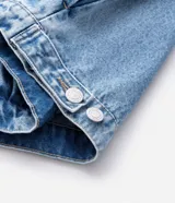 Campera de jean en color azul con efecto desgastado, cuello clásico, cierre frontal con botones metálicos y dos bolsillos con solapa en el pecho.