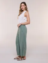 Pantalón crop de lino y rayón, con diseño wide leg de corte holgado, estampado tropical de hojas en tonos verde, azul y marrón sobre fondo blanco. Cuenta con pretina trasera elastizada y bolsillos delanteros.