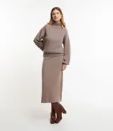 Pollera femenina de corte recto y largo, confeccionada en punto pesado de color beige. Posee cintura elástica con textura acanalada.