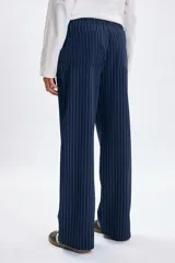 Pantalón de corte recto y tiro medio, confeccionado en tela azul oscuro con estampado de rayas verticales finas en color blanco. Presenta cintura elástica con cordón ajustable y bolsillos laterales.