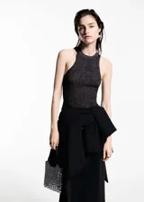 Top de tejido de punto fino con acabado de lúrex brillante, diseño entallado, cuello halter y sin mangas.