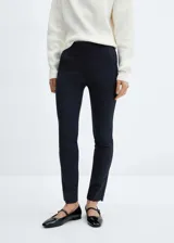 Pantalón de vestir azul marino, de corte skinny y diseño crop de tiro medio, con trabillas, bolsillos laterales y cierre frontal de cremallera y botón.