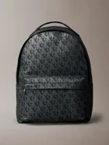 Mochila Calvin Klein con estampado integral de monograma CK en tonos oscuros. Cuenta con un compartimento principal amplio, bolsillo frontal con cierre, asa superior y compartimento interno para laptop.