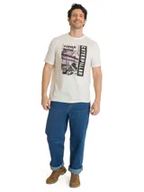 Remera de algodón color beige con cuello redondo y mangas cortas. Cuenta con un gran estampado gráfico frontal en tonos oscuros con la inscripción 'Power For' y 'Caterpillar', acompañado de una ilustración de maquinaria e infraestructura industrial.