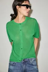 Chaqueta de punto de manga corta y cuello redondo en color verde, con cierre frontal de botones.