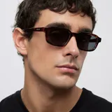 Lentes de sol con montura de diseño rectangular y esquinas redondeadas en estampado carey. Cuentan con lentes oscuras de nylon con protección UV400.