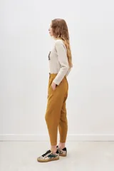 Pantalon estilo babucha color negro, con cintura elastizada y cordón de ajuste, bolsillos diagonales frontales y puños en los tobillos.
