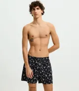 Calzoncillo tipo boxer de tela, color negro con estampado temático de la serie Stranger Things en color blanco. Cuenta con cintura elástica y está confeccionado en algodón ligero y transpirable.