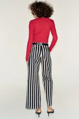 Pantalón de tiro alto y pernera recta con estampado de rayas verticales en tonos azul, marrón y beige. Incluye un cinturón delgado de color marrón oscuro con hebilla metálica dorada.