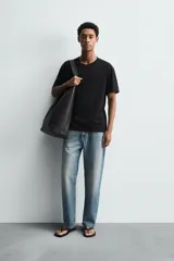 Camiseta de corte relajado confeccionada en algodón ligero, con cuello redondo y mangas cortas con bordes de acabado irregular.