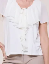 Blusa de corte recto Cable & Gauge, color blanco, con escote redondo, lazo central para anudar y volados fluidos en el frente y las mangas.