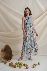 Vestido largo de crepe de seda estampado con flores en tonos celeste, rosa y verde. Tiene cintura drapeada y falda con paneles sueltos.