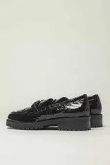 Mocasín de cuero vacuno color marrón con acabado charol, forro y plantilla de cuero vacuno y suela de goma.