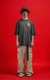 Remera de algodón premium, color gris oscuro con efecto lavado, corte oversize y manga corta. Presenta un pequeño estampado frontal de Mickey Mouse en un recuadro naranja.