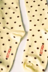 Medias largas color marrón con estampado de lunares celestes. Tienen un corazón rojo bordado con la letra 'R' en blanco en la parte superior y la palabra 'Rotunda' en rojo en el lateral del pie.