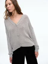 Cardigan de punto con hilo brillante, cuello en V y cierre frontal con botones. Presenta un diseño holgado con mangas largas y puños acanalados, confeccionado en una mezcla suave de viscosa.