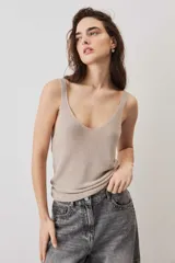 Blusa de punto color marrón chocolate con escote en V y breteles finos, de caída suave y textura tejida con sutil brillo.