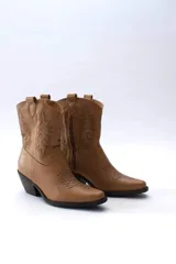 Botas cortas estilo western (texanas) color camel, confeccionadas en cuero, con bordados decorativos en el caño y puntera, y cierre lateral. Poseen taco medio y punta afilada.