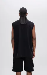 Camisa sin mangas de corte oversize, color negro, confeccionada en tejido twill. Presenta cuello clásico, cierre frontal oculto y un bolsillo tipo cargo en el pecho con detalle de remaches metálicos.