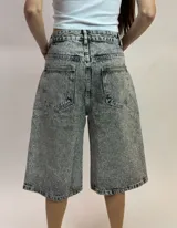 Bermuda de denim gris con efecto acid wash y apliques de strass en toda la prenda, de tiro medio y corte holgado.