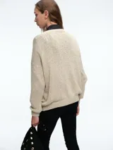 Cardigan de punto con hilo brillante, cuello en V y cierre frontal con botones. Presenta mangas largas con puños acanalados y un diseño de calce holgado.