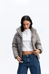 Campera puffer negra con capucha, diseño corto y acolchado, cierre frontal con botones a presión y puños ajustados.