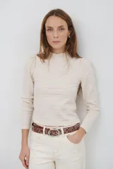 Polera de manga larga en color blanco hueso, con cuello alto estilo mock neck con detalle de volados y textura acanalada fina.