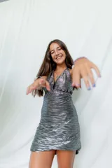 Vestido largo con estampado de hojas en tonos azul y dorado, con escote halter y espalda descubierta.