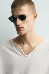 Camiseta de corte relajado con cuello redondo amplio tipo panadero, con detalle de botones y acabado irregular. Manga corta.