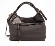 Cartera negra con doble asa de hombro y correa larga extraíble. La parte superior es de cuero sintético arrugado y la parte inferior es de tela con textura de pequeños rombos.