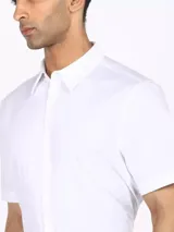 Camisa de vestir blanca de manga corta, corte slim, con cuello de punta y cierre frontal de botones.